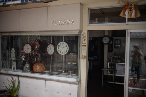 An old clock store with old cloks on display in the window.