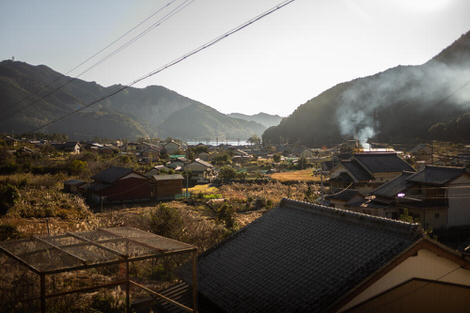 Looking down over Mikisato from the vantage of the train station, small houses with generous yards, smoking billowing from yard fires burning post-harvest refuse, the hint of the ocean in the background. 